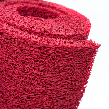 Close-up of a roll of red spaghetti mat on a white background