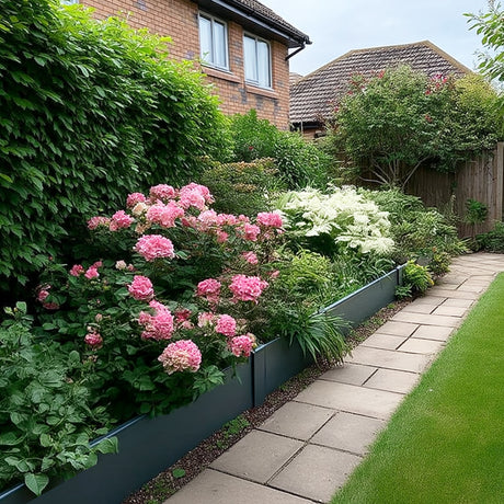 Grey metal raised garden bed bordering a stone-paved walkway.